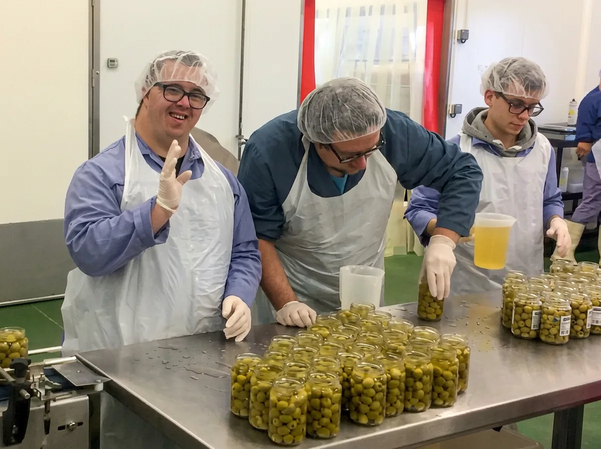 Travailleurs de l’ESAT de Savenay remplissant des bocaux d’olives dans l’atelier Plein Sud